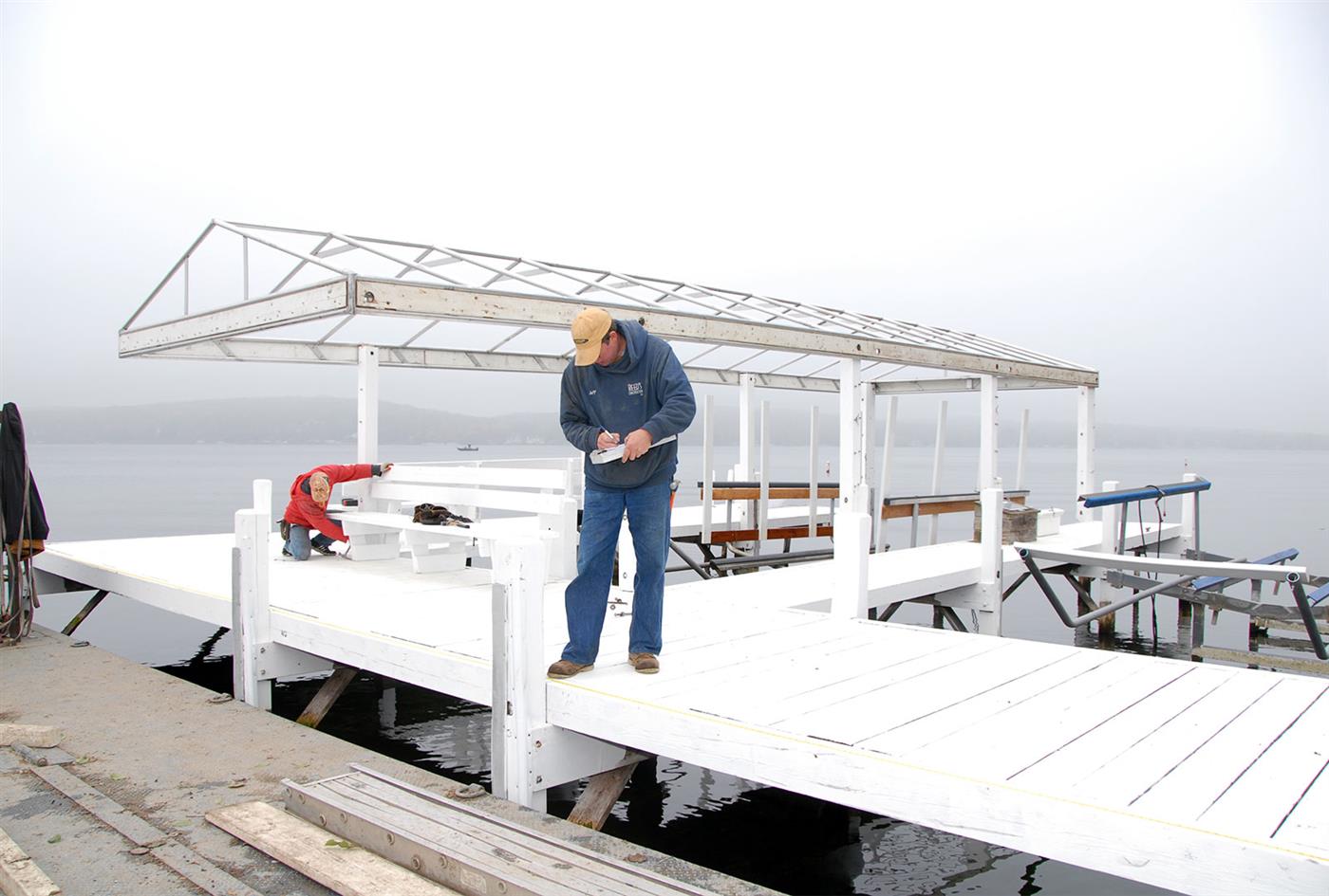 Reed's crew member installing a white pier with canopy frame
