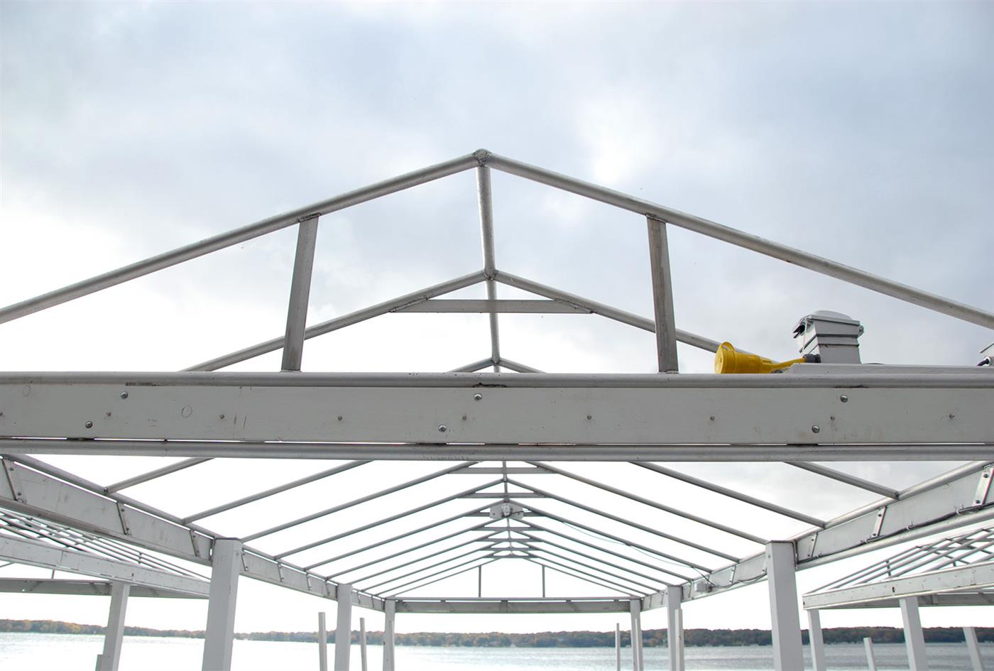 Rebuilding a white pier canopy frame over the water
