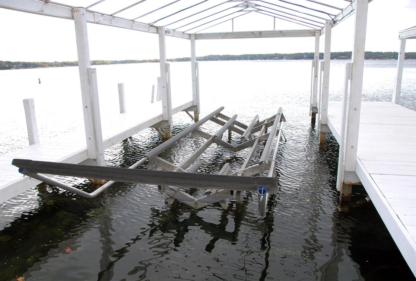 Boat lift frame installed under a white pier canopy